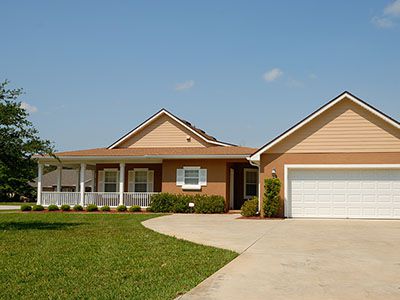 Brick home with red rock landscaping and manicured yard.